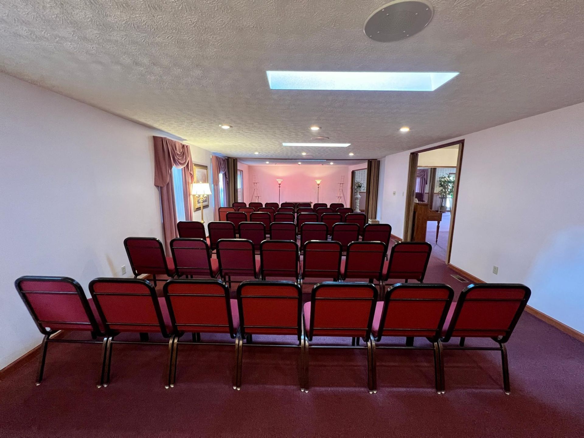 A row of red chairs are lined up in a room.