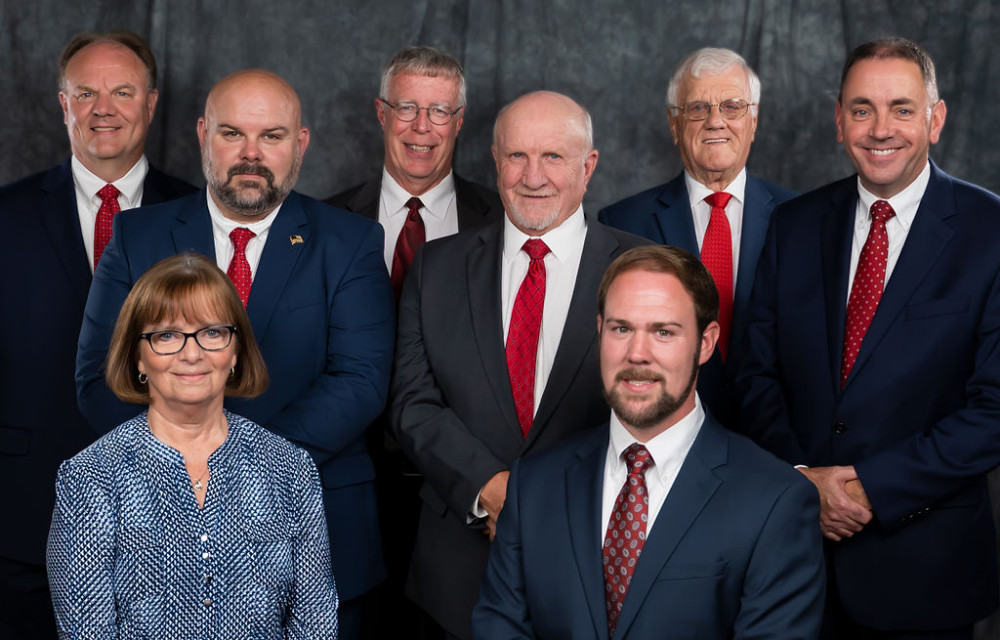A group of people in suits and ties are posing for a picture.