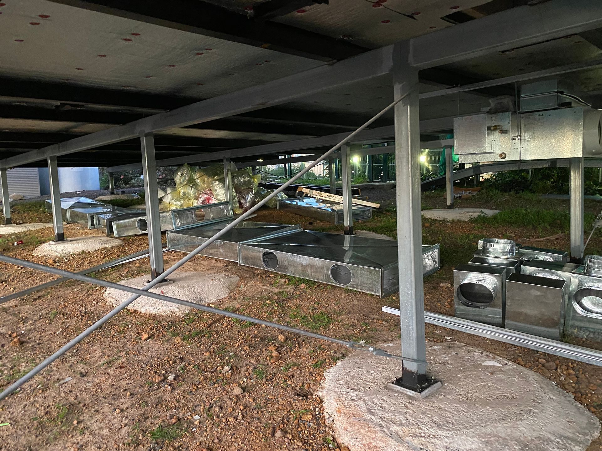 View from underneath solar panels; metal support beams on concrete bases with electrical components. — Airweld Services Pty Ltd in Kiama, NSW