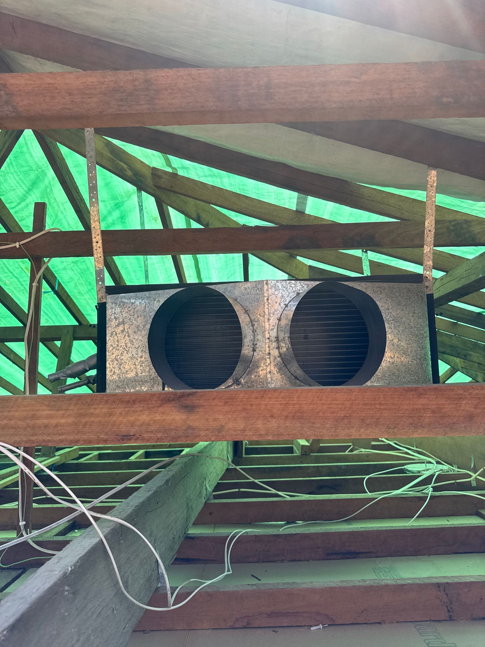 Two circular vents set in a rectangular box, suspended from wooden rafters. Green tarp visible. — Airweld Services Pty Ltd in Ulladulla, NSW