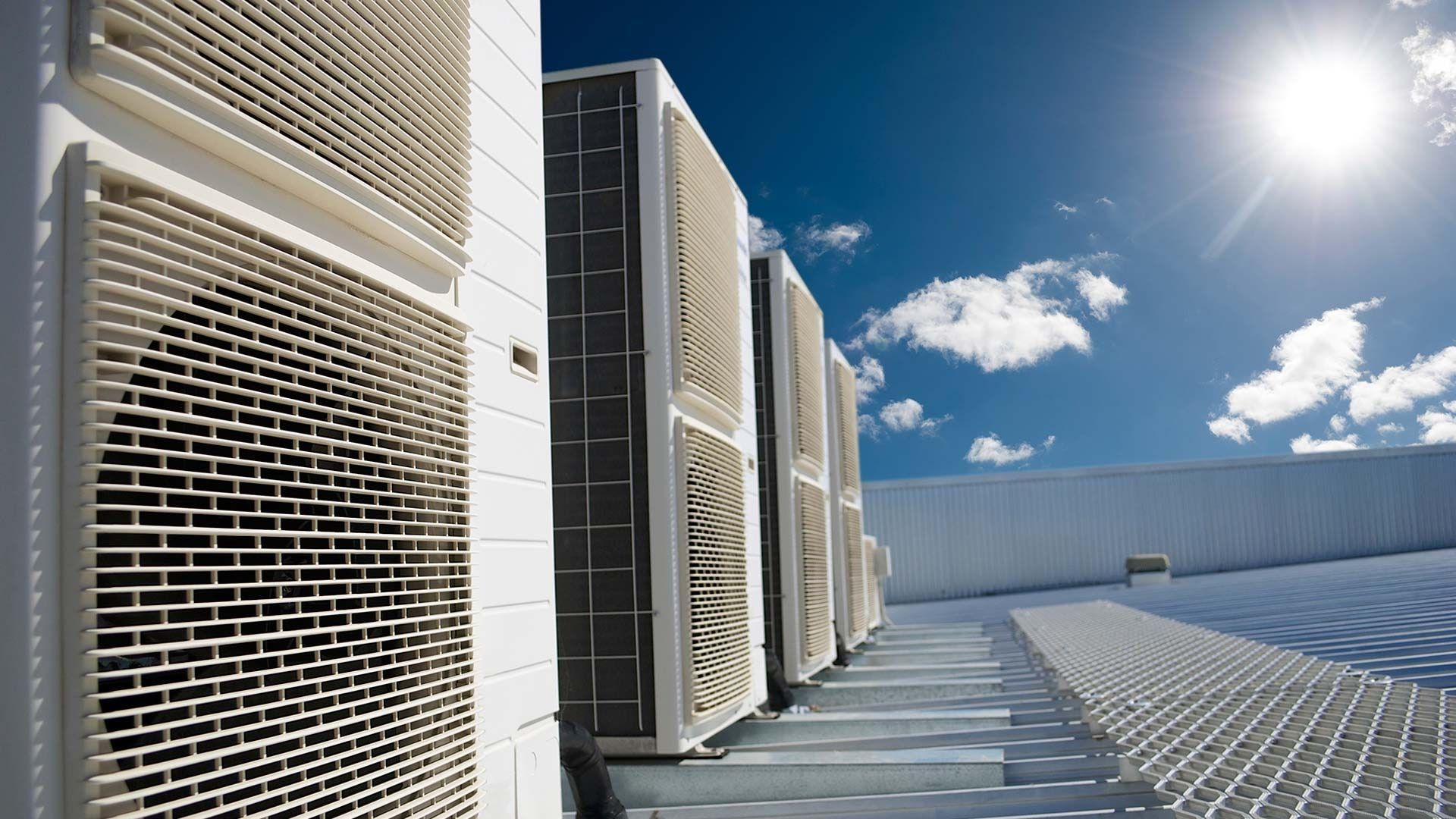 Air conditioning units on a rooftop, sunny day with blue sky and white clouds. — Airweld Services Pty Ltd in Shellharbour, NSW