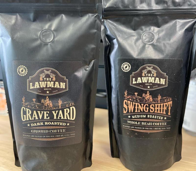 Two bags of lawman coffee are sitting on a table