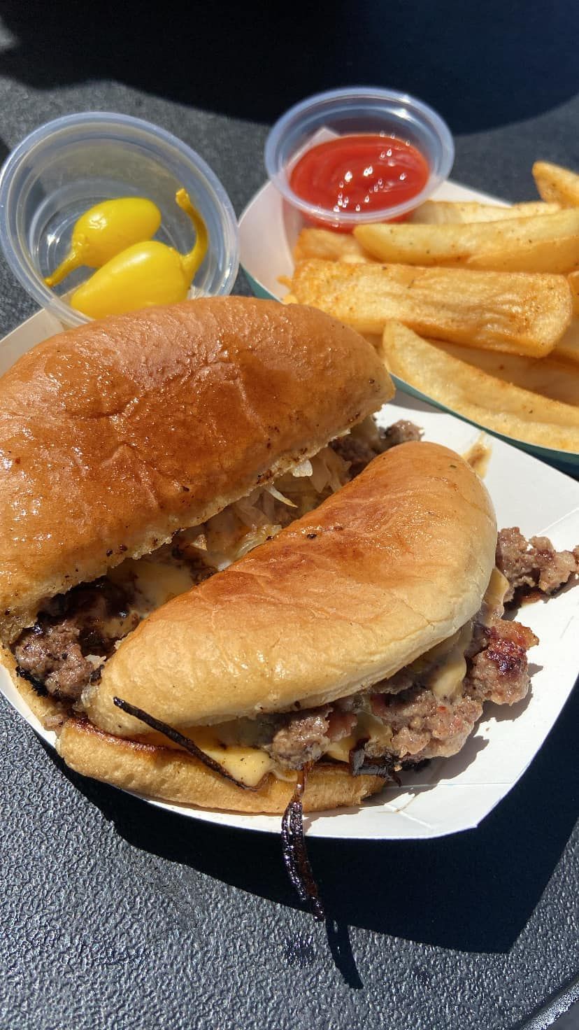 A hamburger and french fries are on a paper plate.