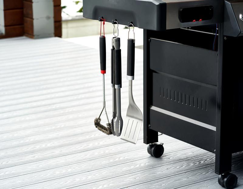 A grill with a bunch of utensils attached to it