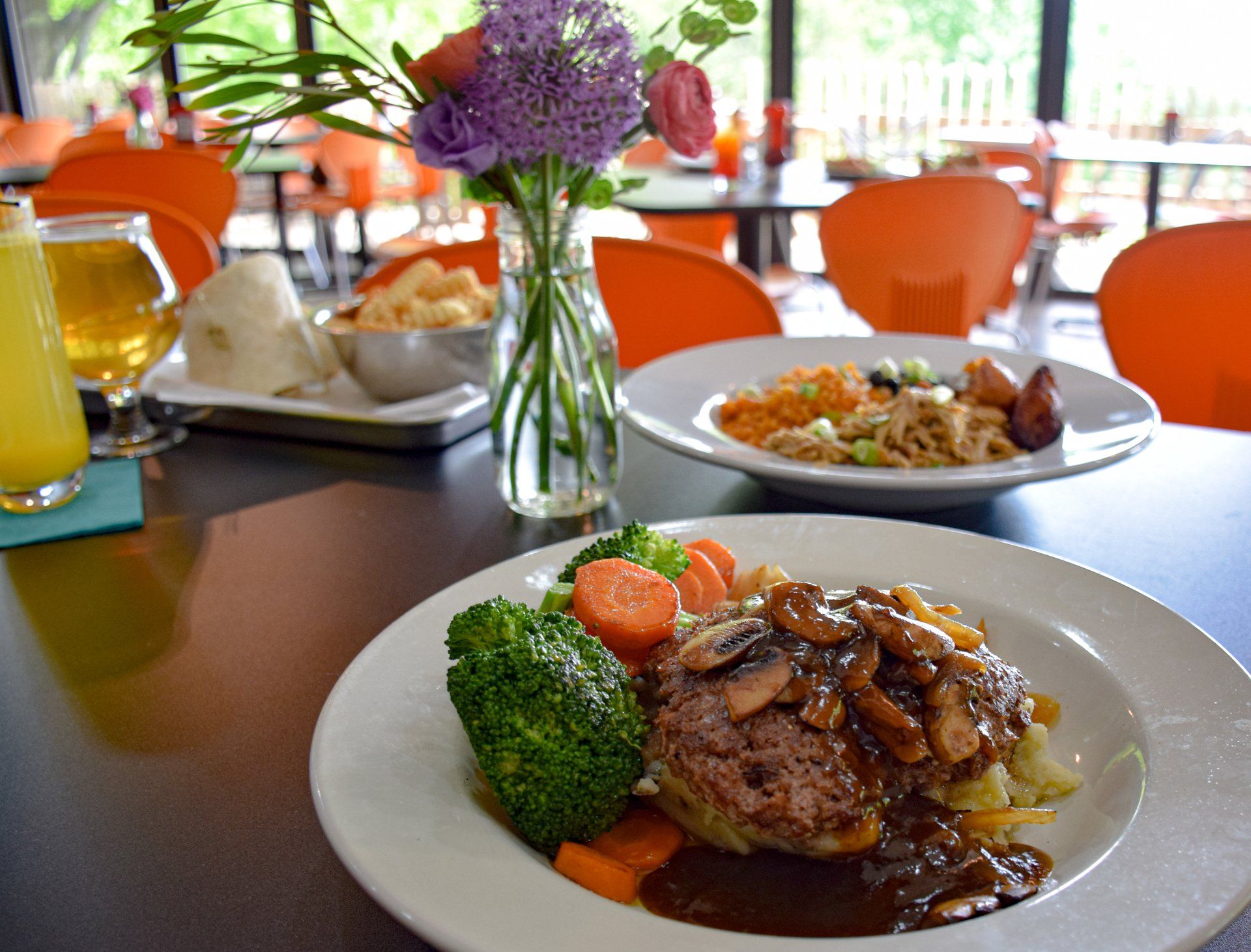 A plate of food with broccoli and carrots on a table in a restaurant.