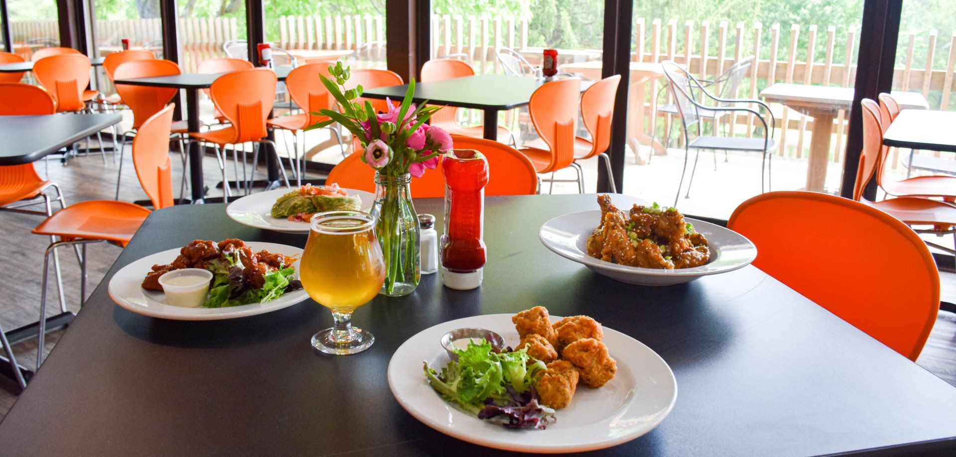 A restaurant with plates of food and a glass of beer on the table