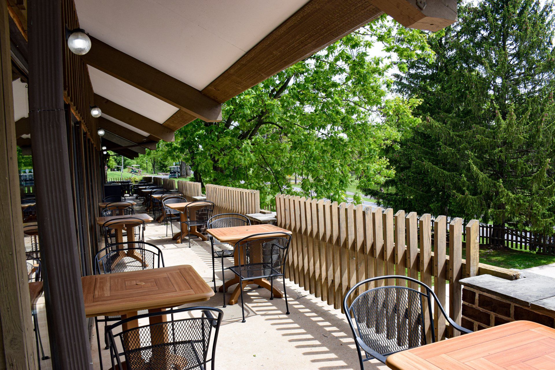 There are many tables and chairs on the balcony.