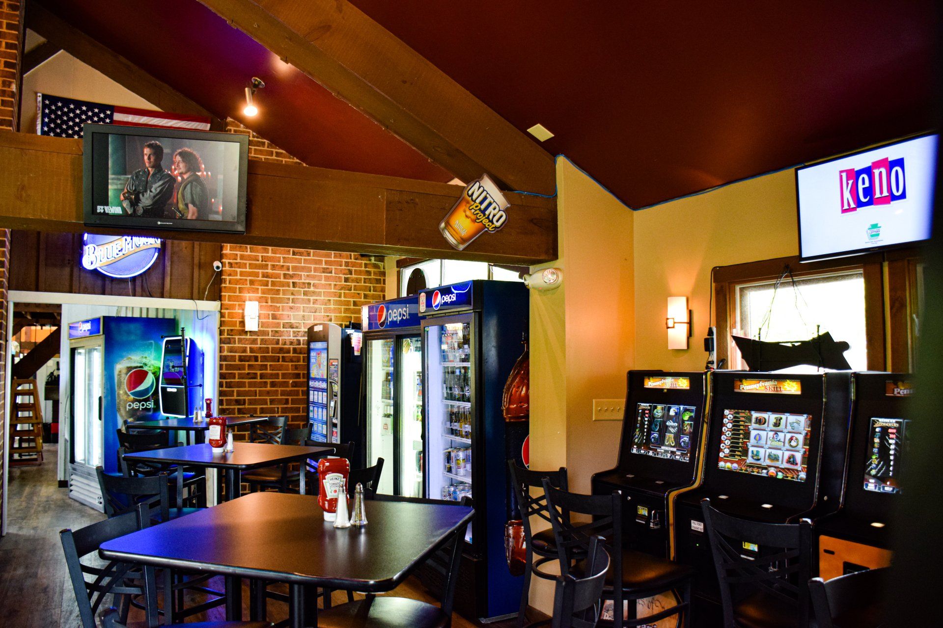 A restaurant with tables and chairs and a keno sign on the wall