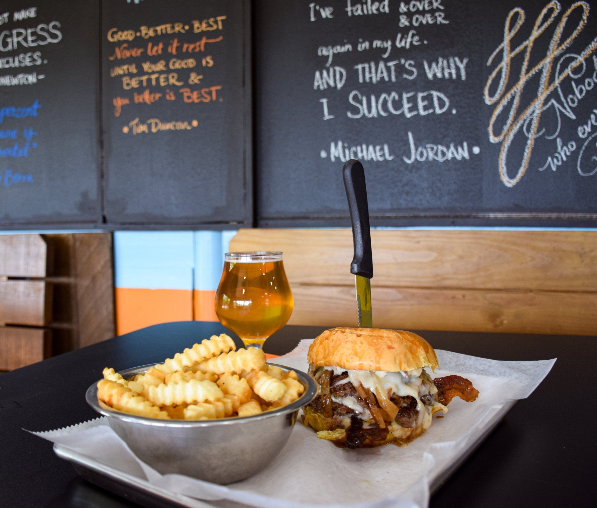 A hamburger and a bowl of french fries on a table