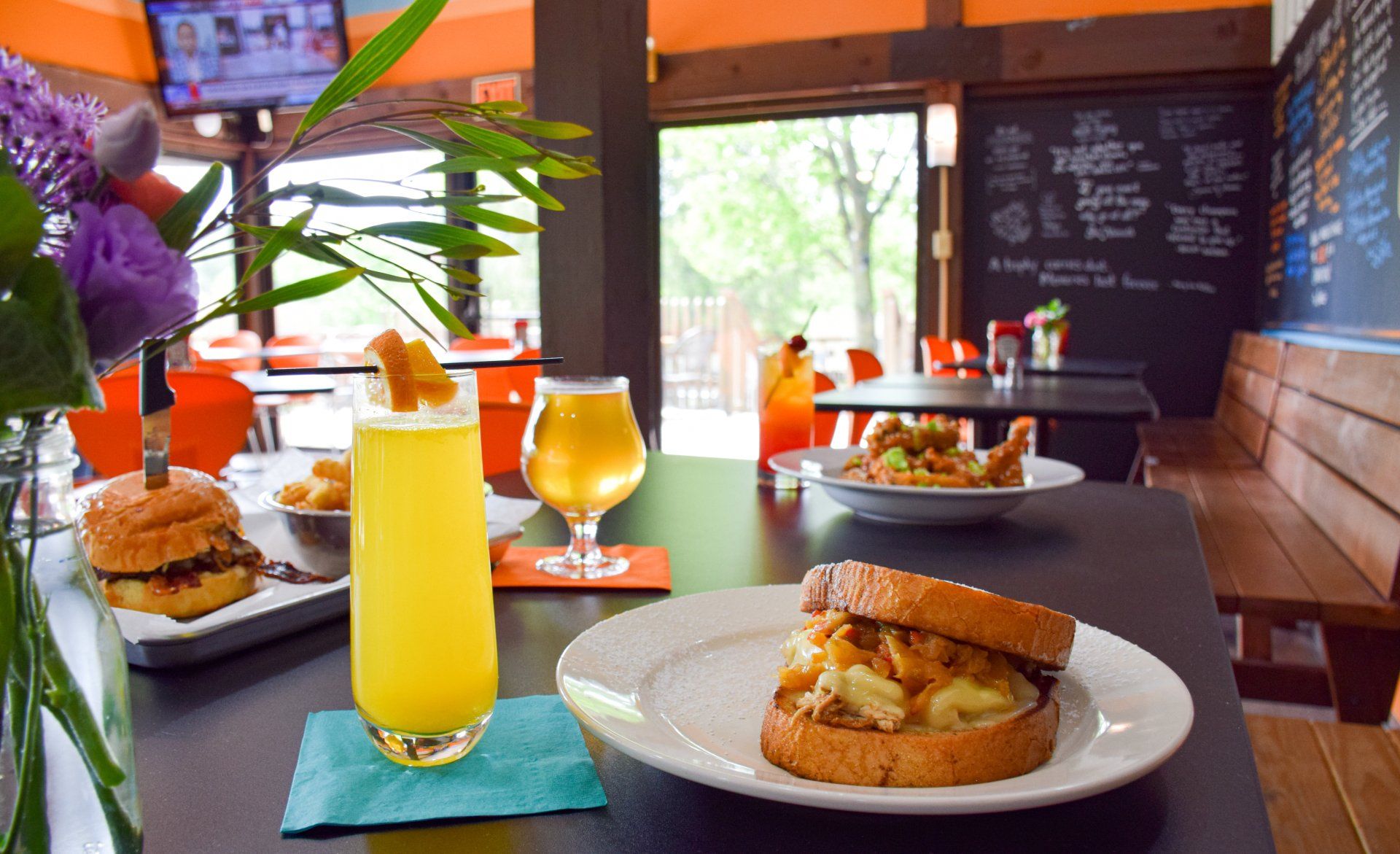 A sandwich and a drink are on a table in a restaurant.