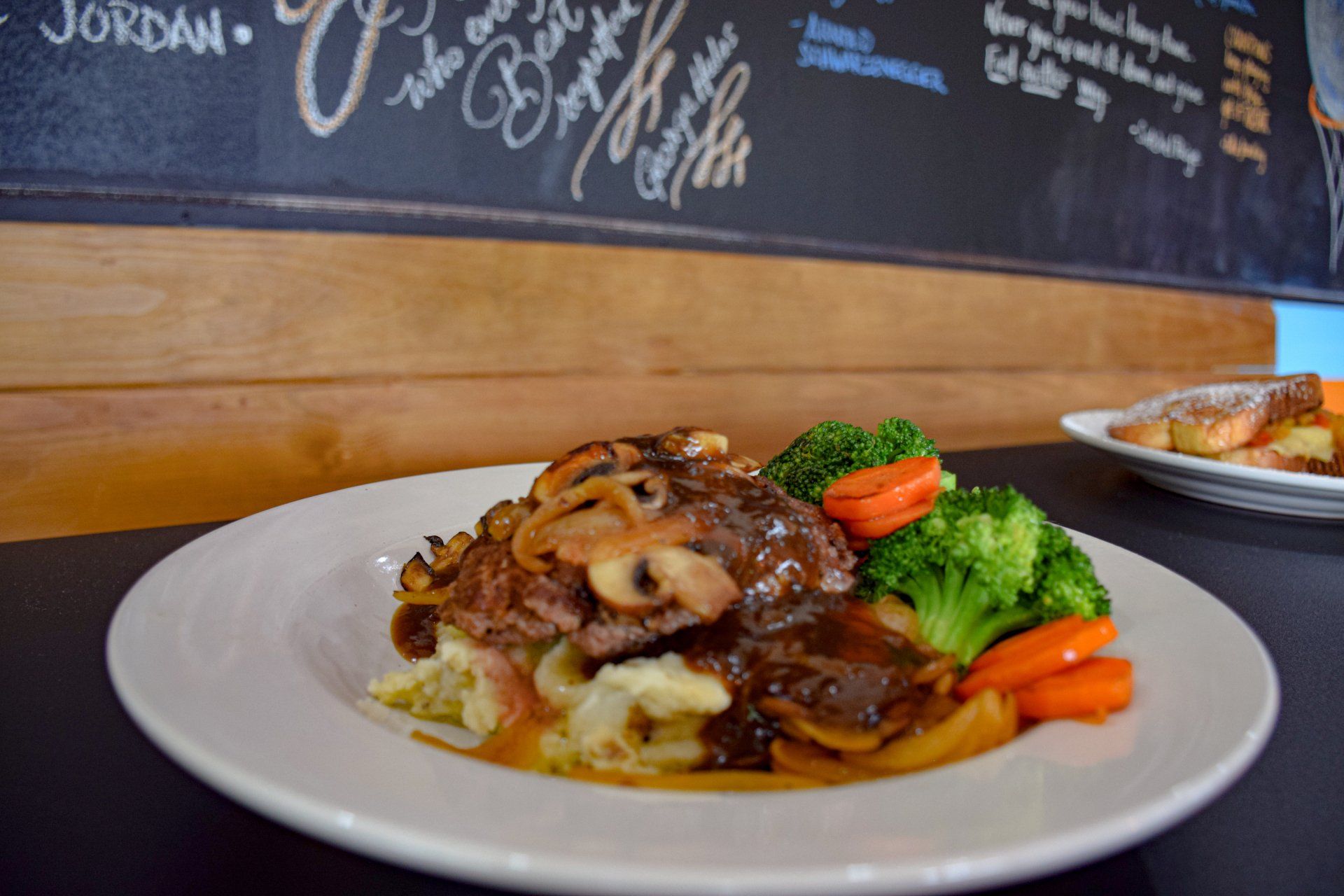 A plate of food with broccoli , carrots and mashed potatoes on a table.