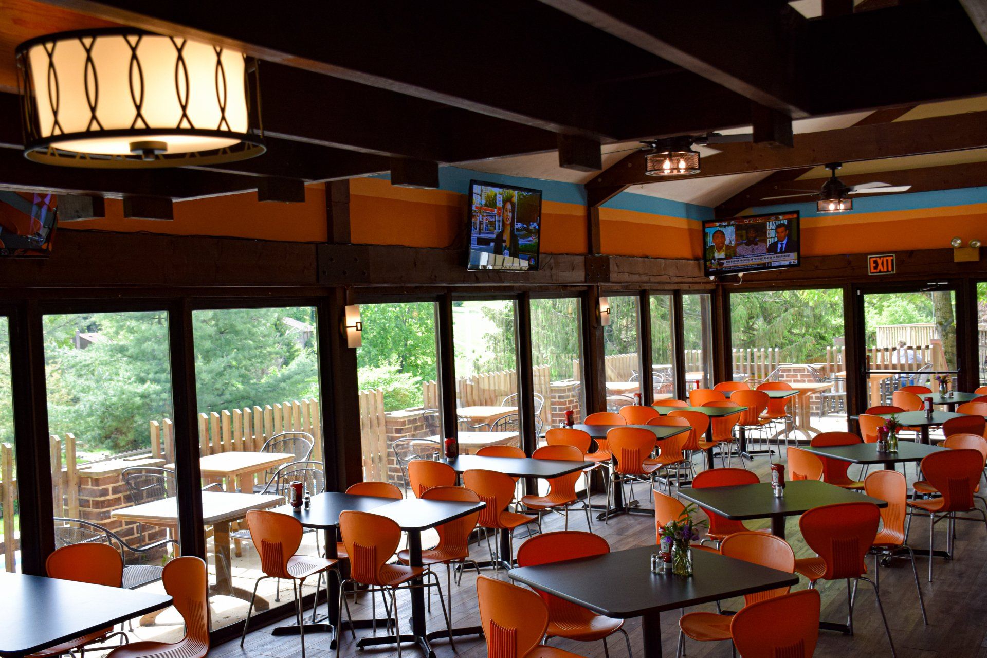 A restaurant with lots of tables and chairs and a sign that says exit