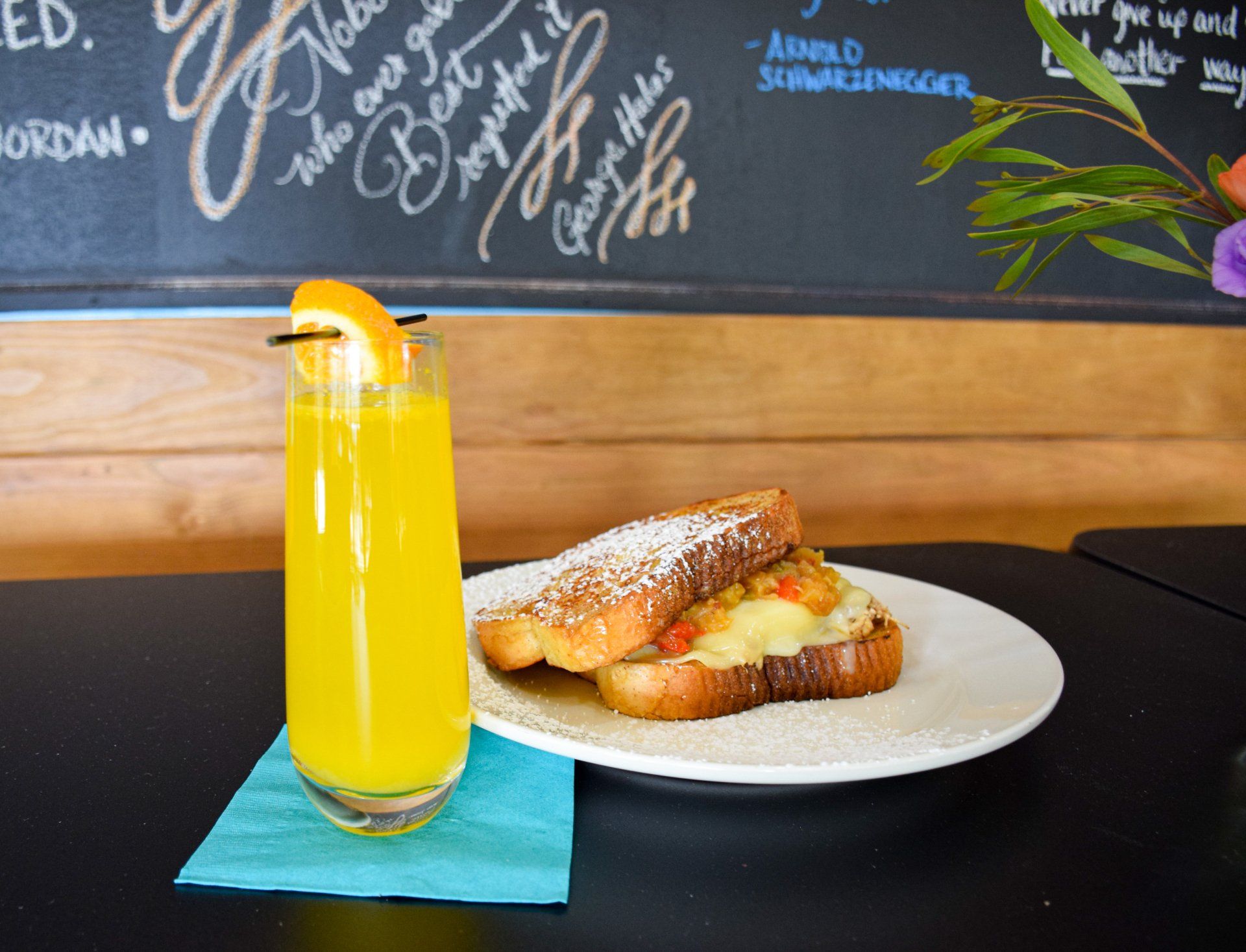 A plate of food and a glass of orange juice on a table.
