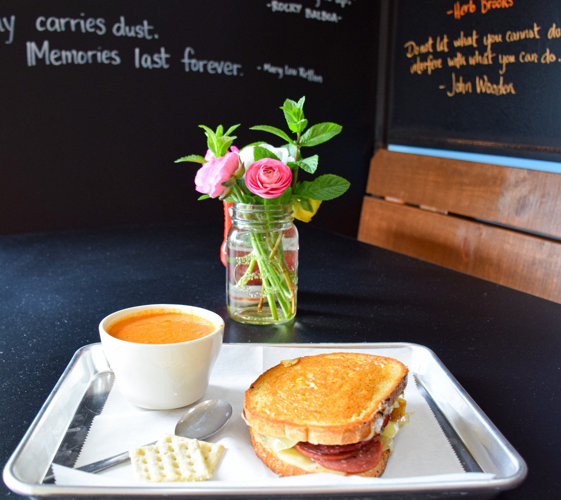 A tray with a grilled cheese sandwich and a cup of coffee