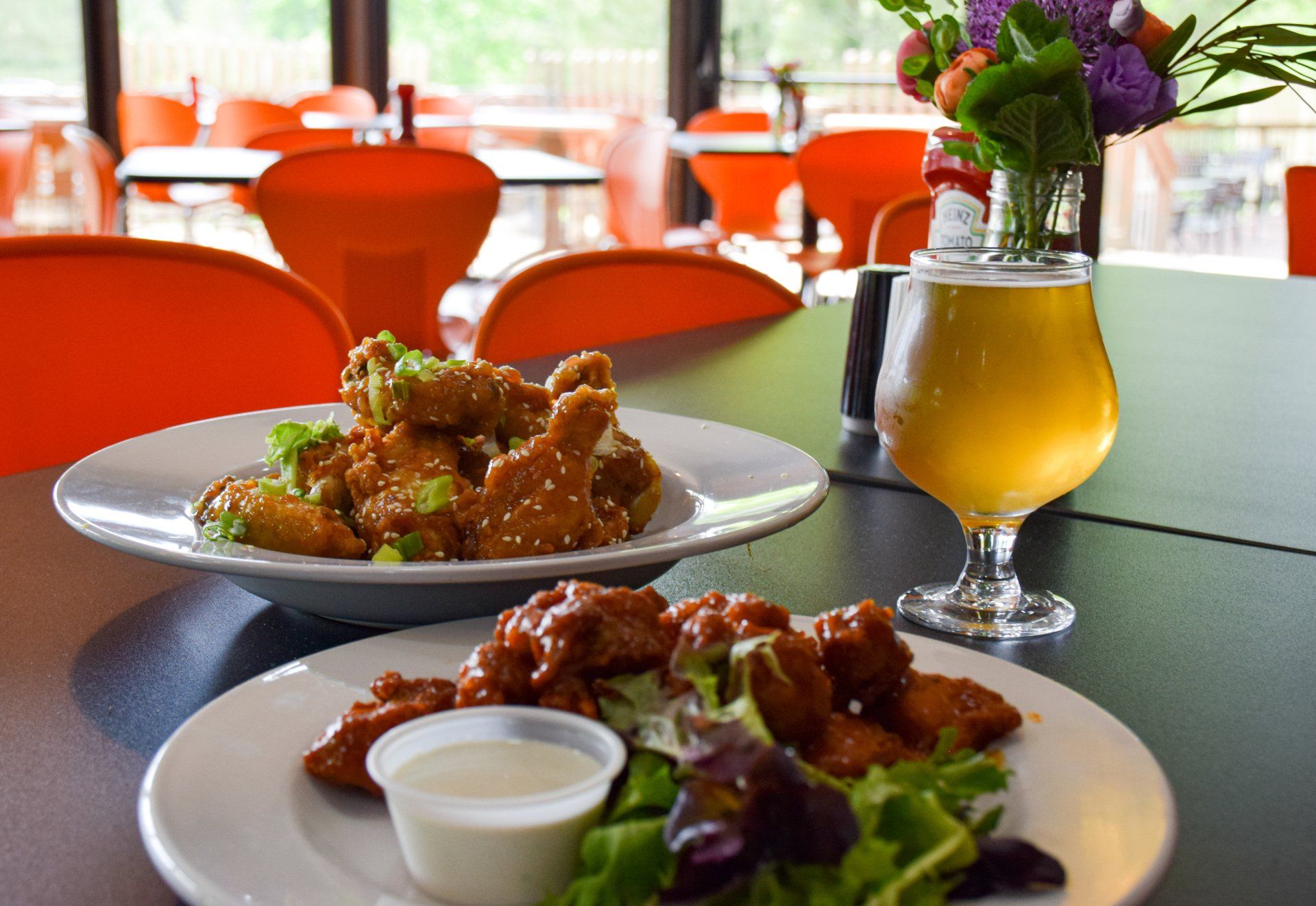 A plate of food and a glass of beer on a table.