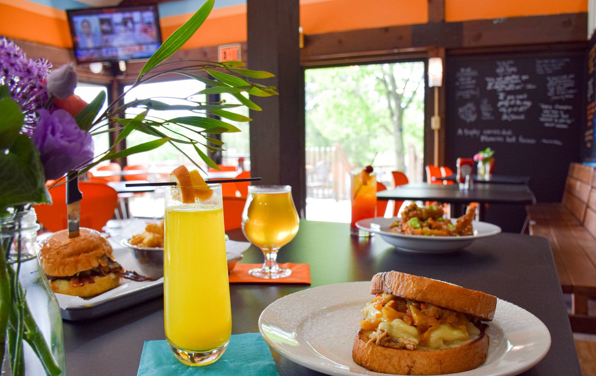 A sandwich and a drink are on a table in a restaurant.
