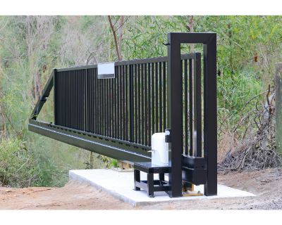 A black sliding gate is sitting on top of a concrete platform.