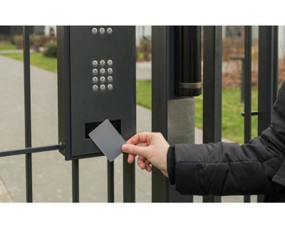 A person is using a card to open a gate.