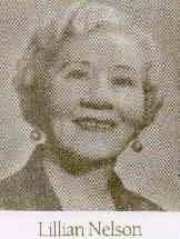 Lillian Nelson, smiling, in a dark jacket with earrings.