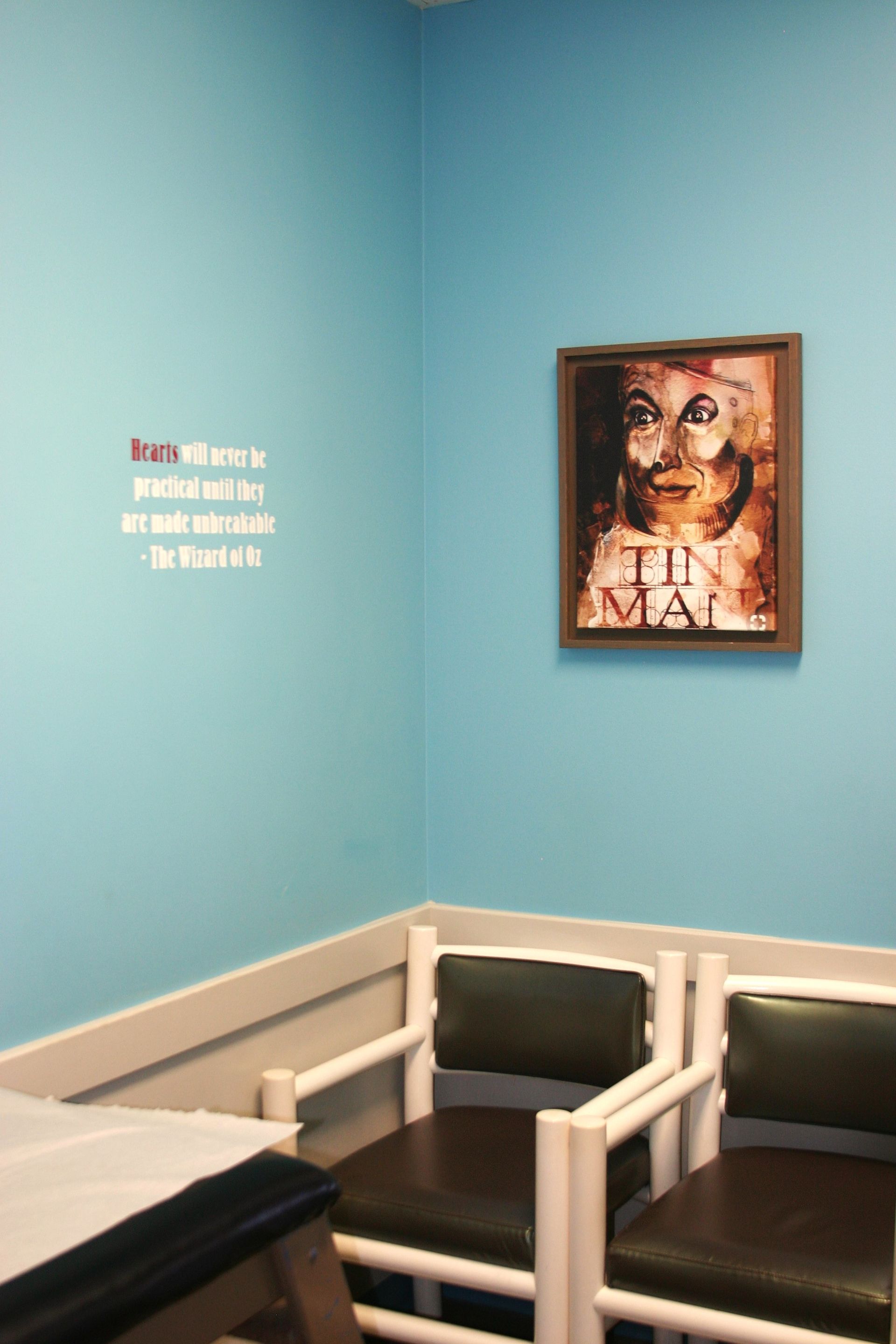A waiting room with two chairs and a picture on the wall