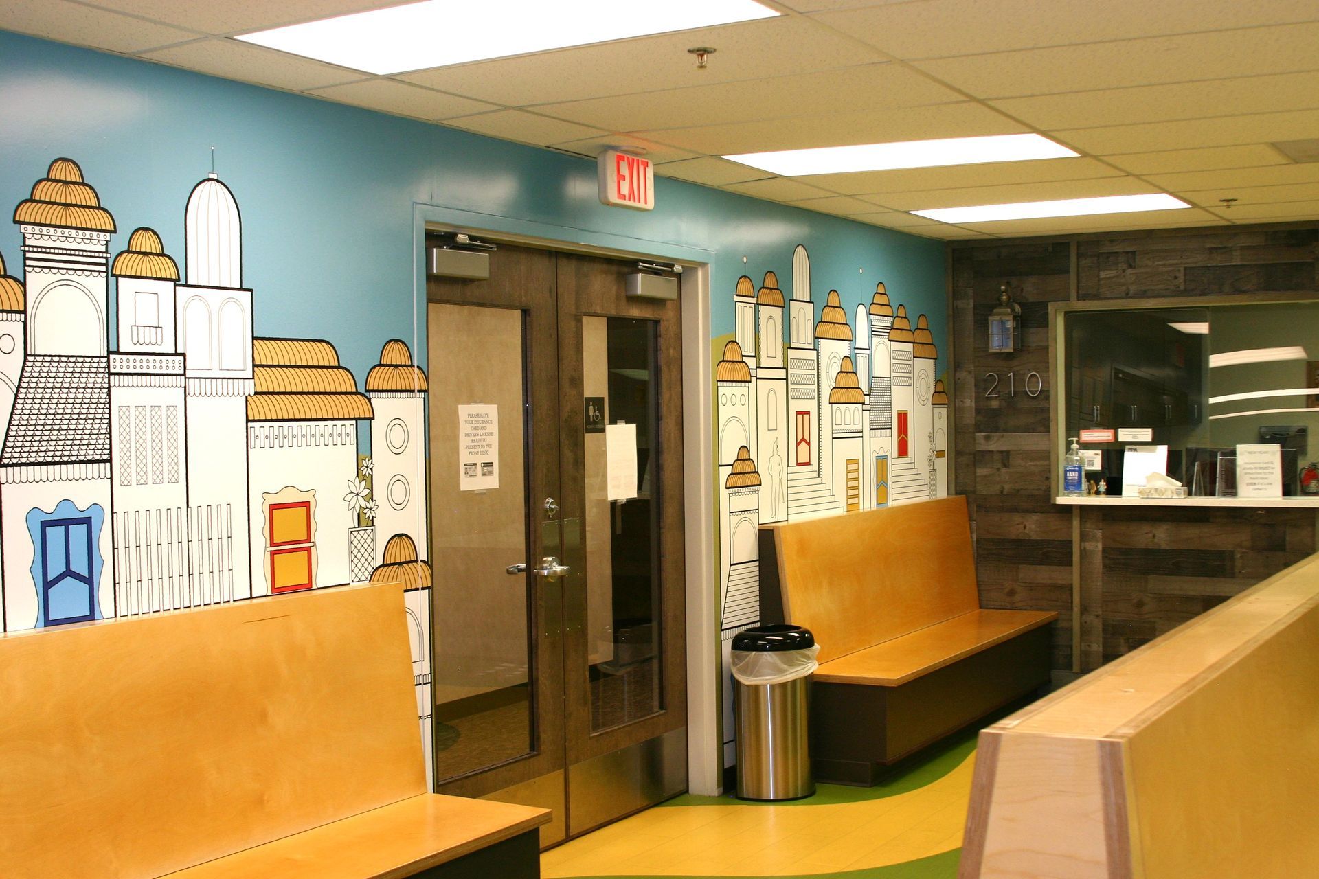 A waiting room with a painting of a city on the wall