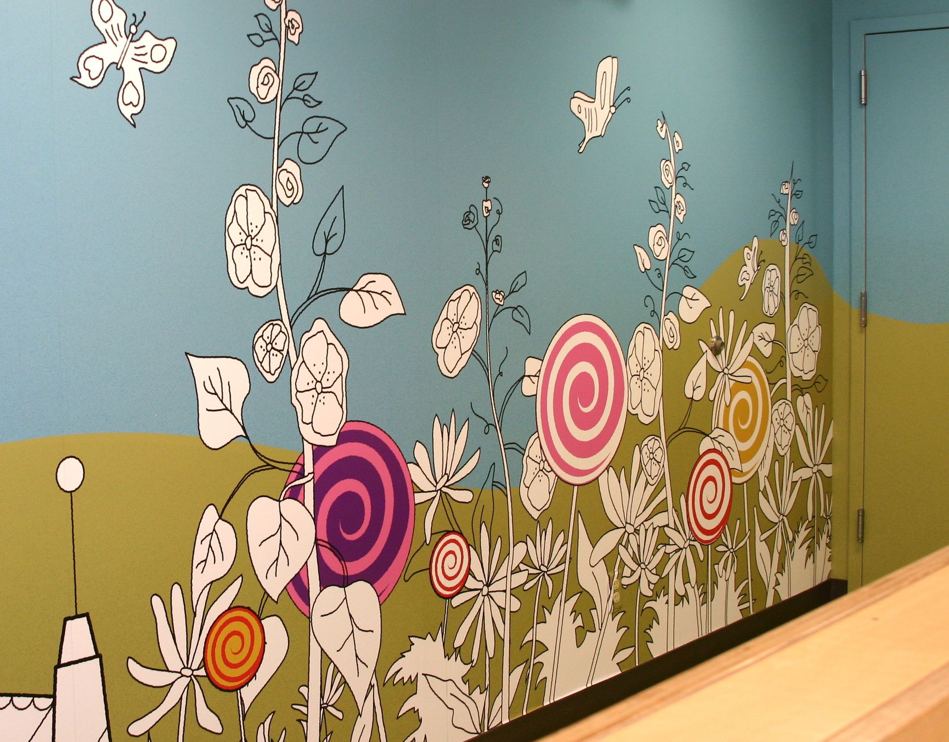 A wall with flowers and lollipops painted on it