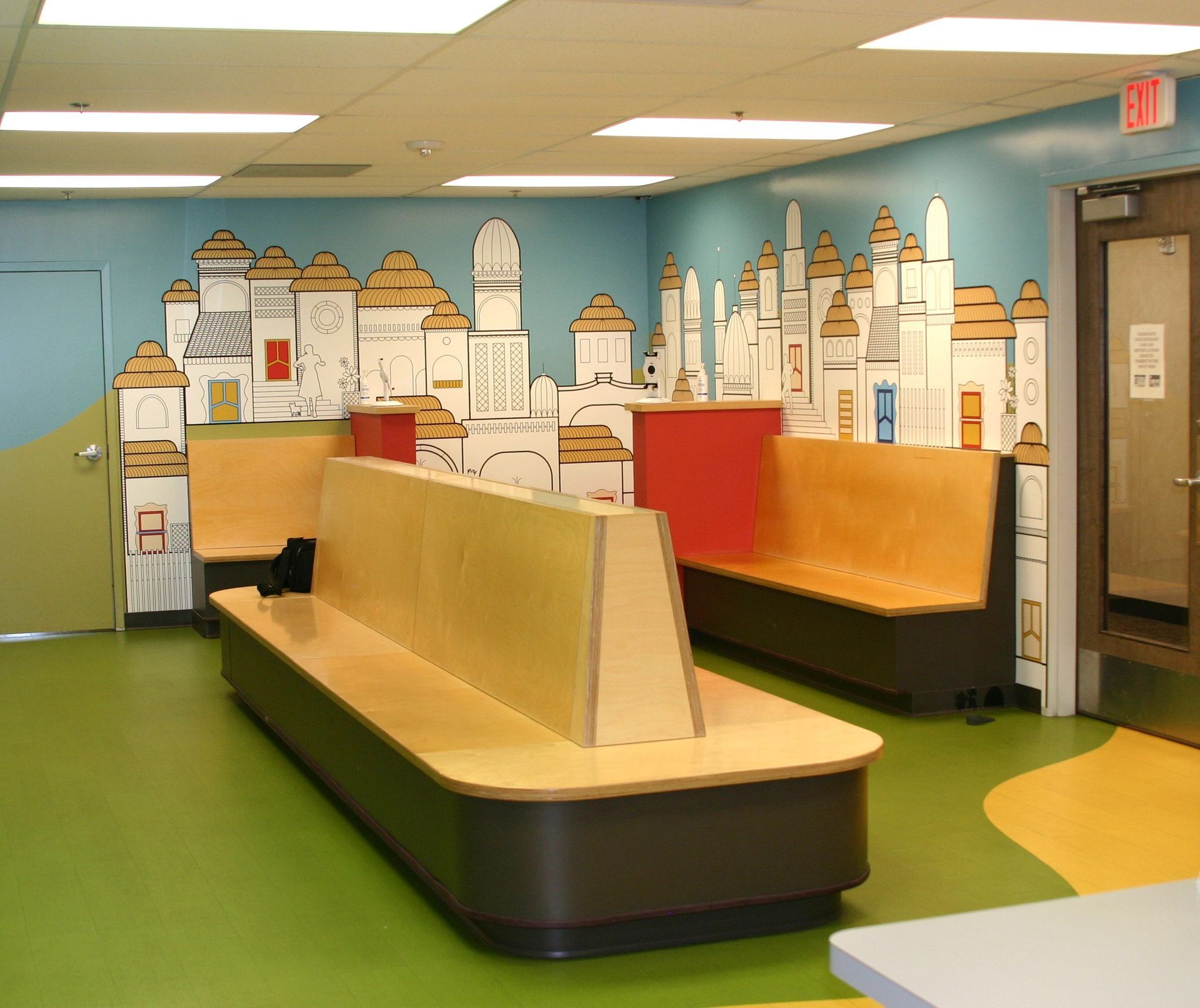 A waiting room with a mural of a city on the wall