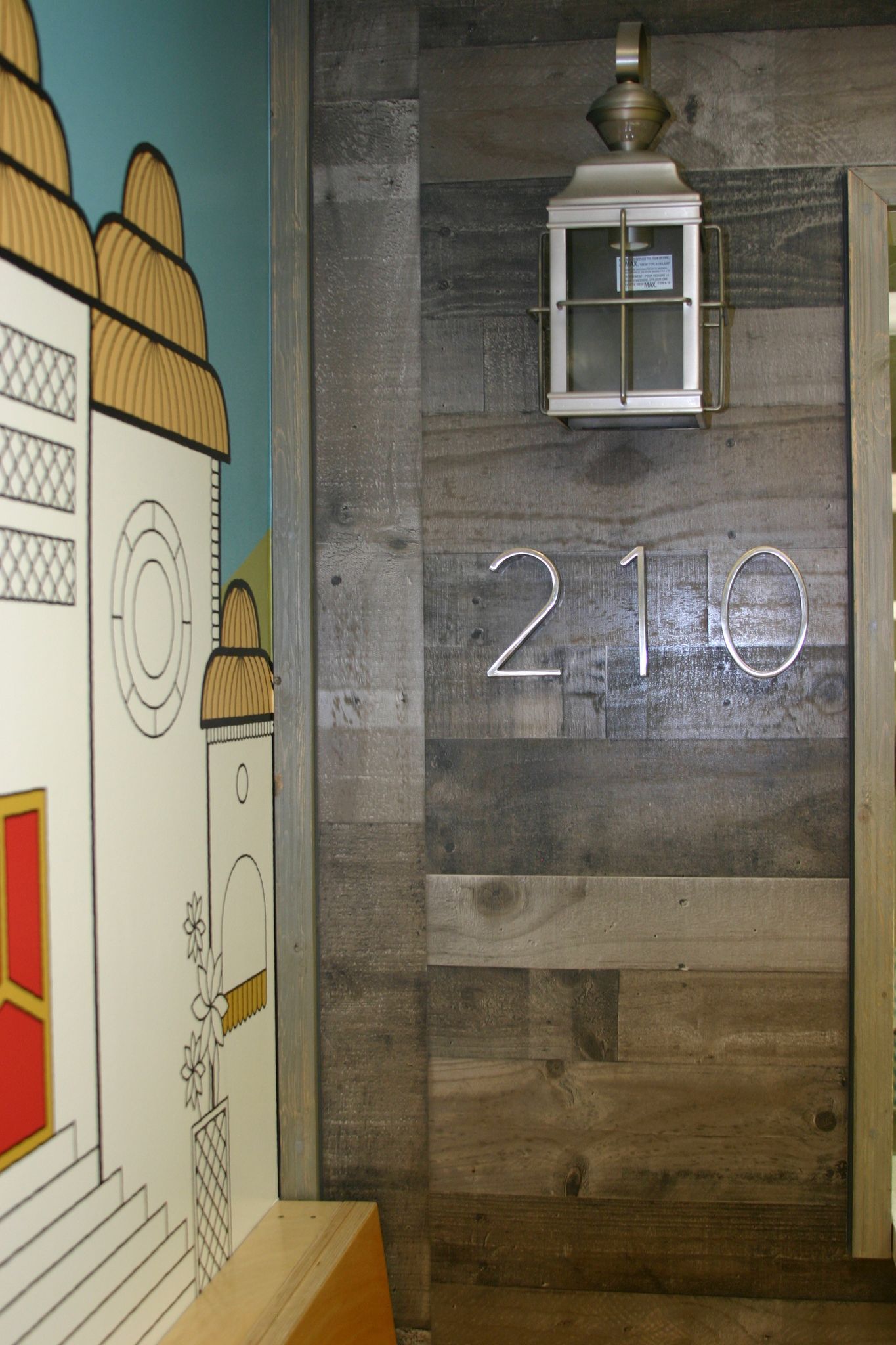 A wooden wall with the number 210 written on it