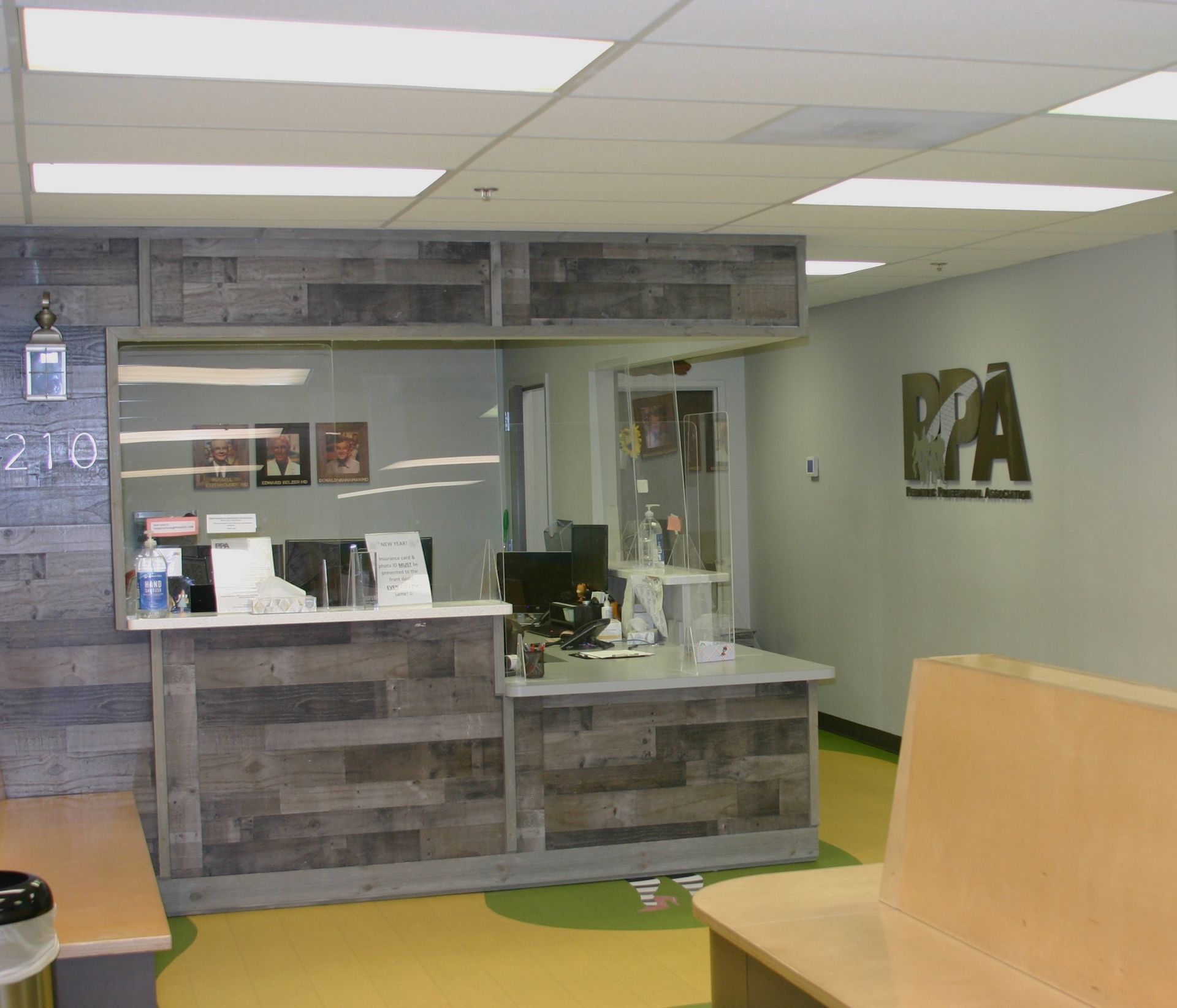 A waiting room with a wooden bench and a wooden counter.