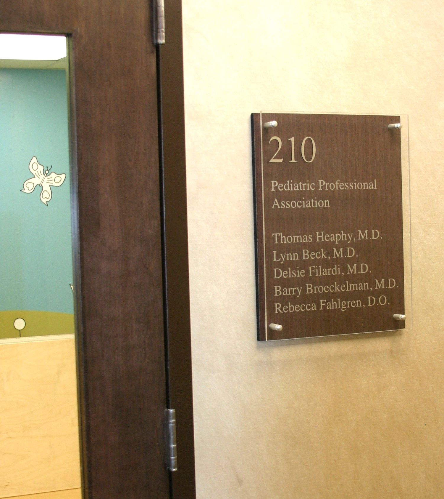 A door with a sign that says 210 pediatric professional association