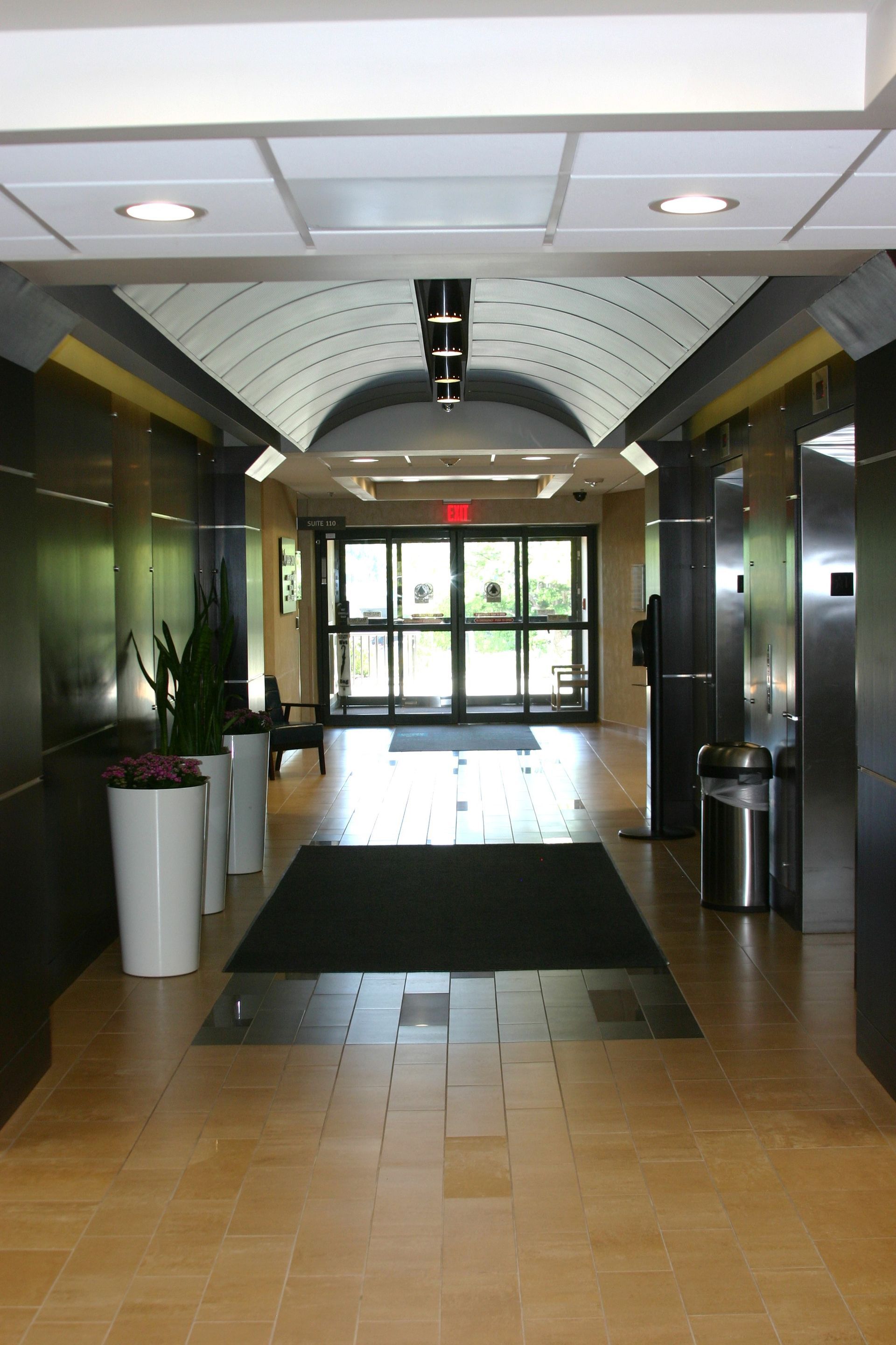 A hallway with a red exit sign on the ceiling