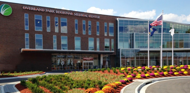 A large building with a lot of windows and flowers in front of it.