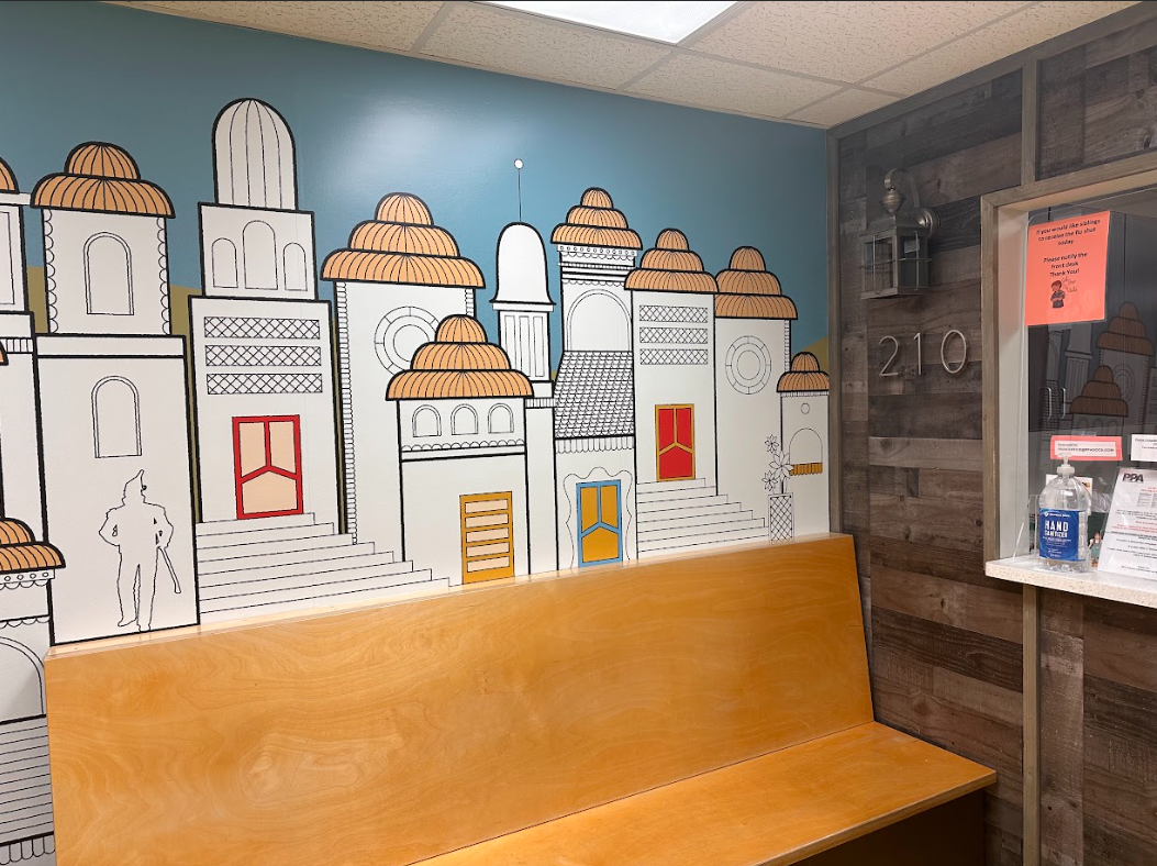 A waiting room with a bench and a mural on the wall.