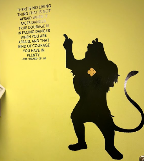 A silhouette of a lion with a quote on the wall