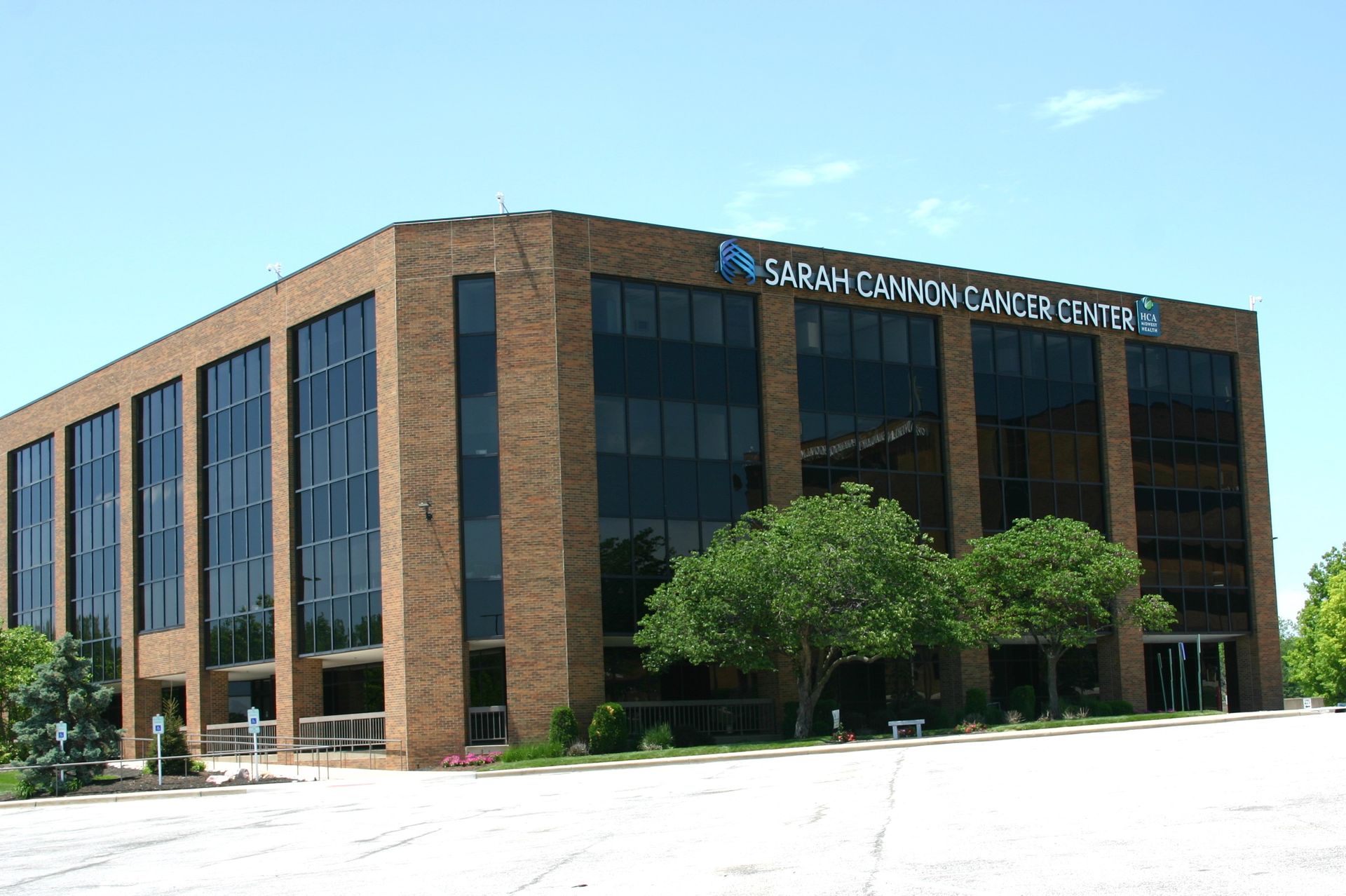 A large brick building with a lot of windows and trees in front of it