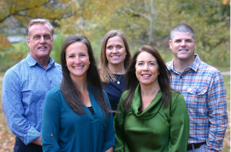 A group of people are posing for a picture in a park.