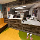 A waiting room with a counter and a bench.