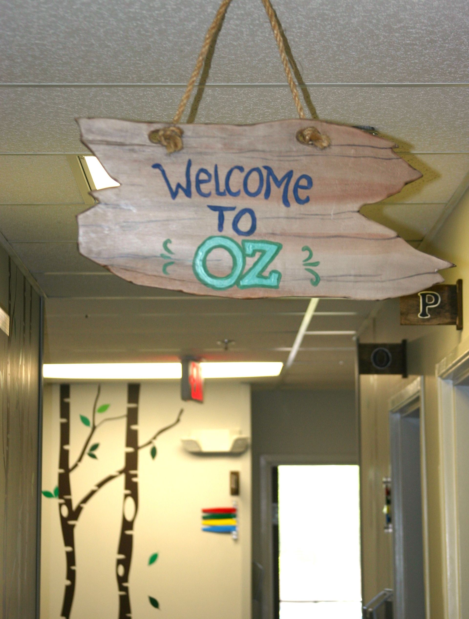 A welcome to oz sign hangs from the ceiling of a hallway