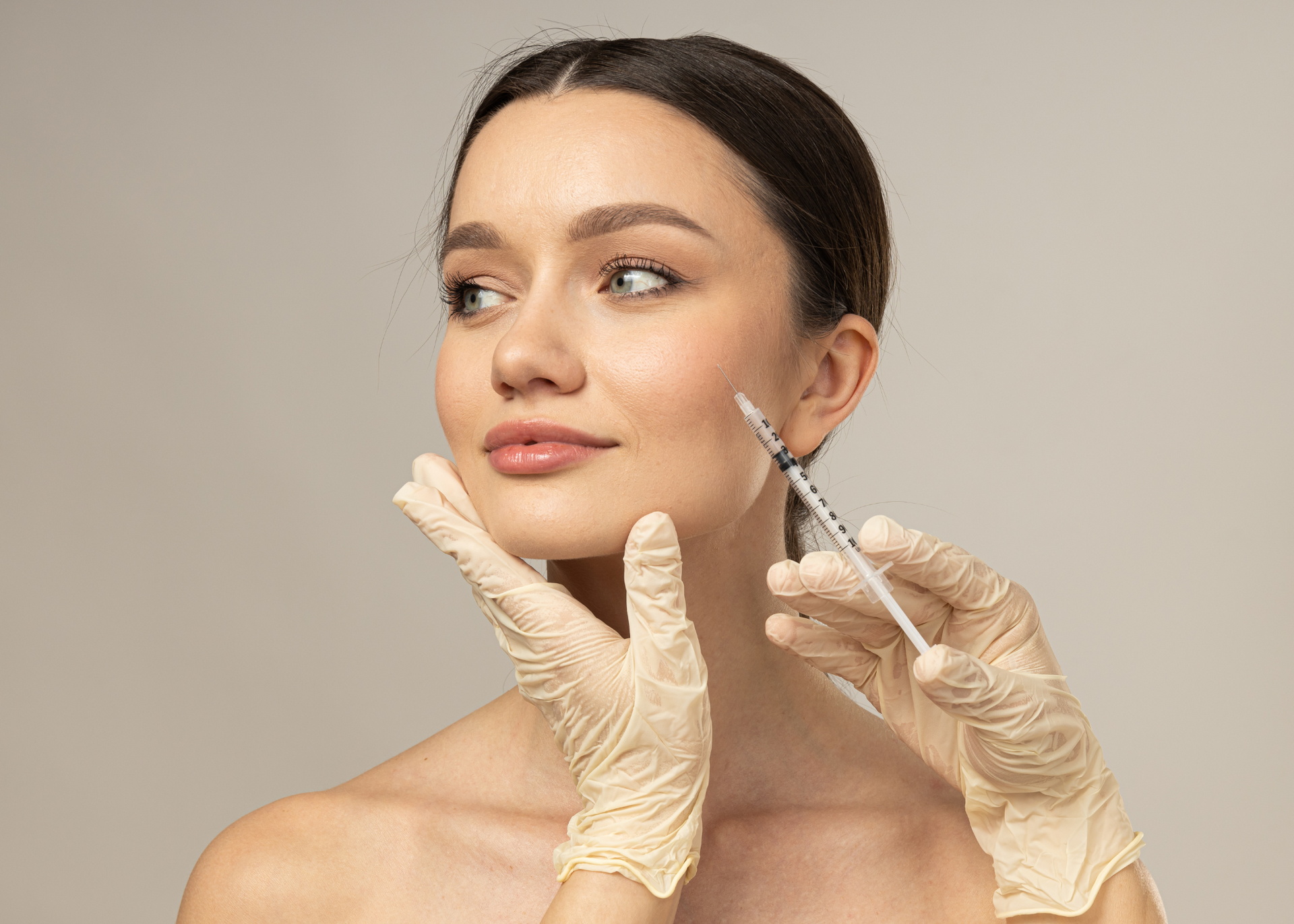 A woman is getting a botox injection in her face.