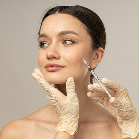 A woman is getting a botox injection in her face.