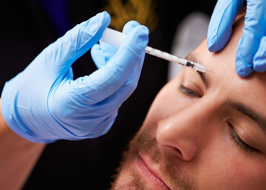 A man is getting a botox injection on his forehead.