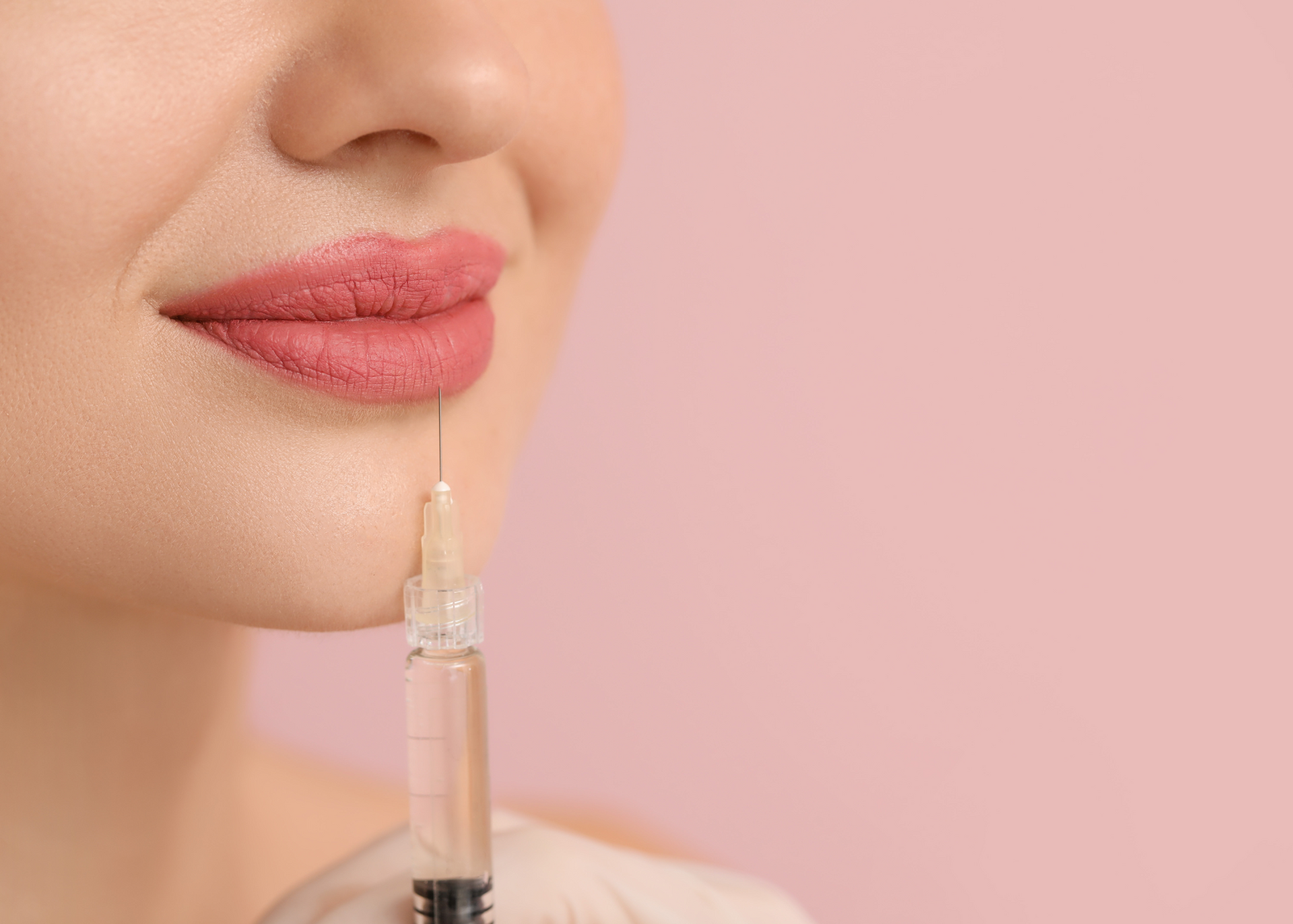 A woman is getting a botox injection in her lips.