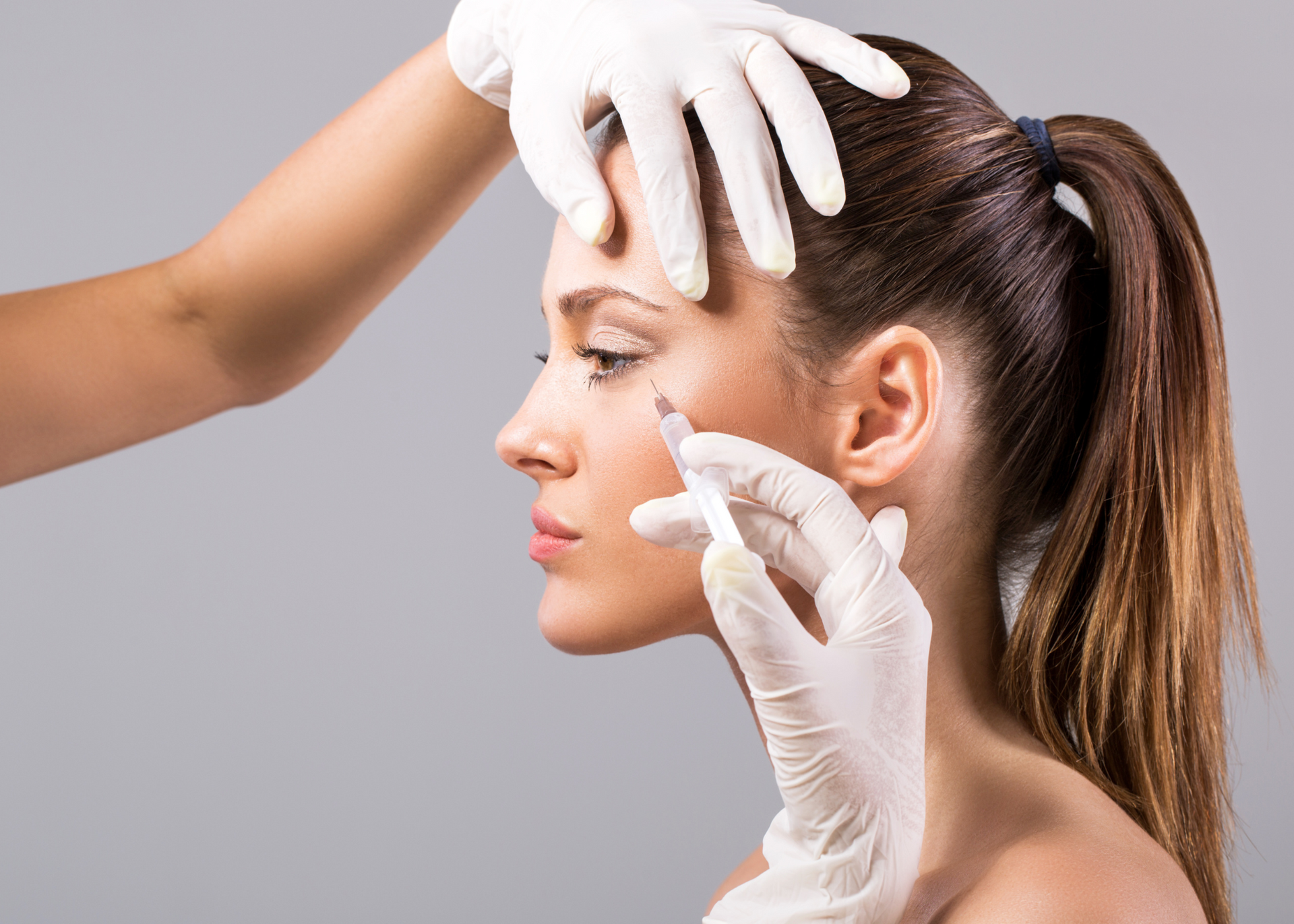 A woman is getting a botox injection in her face.