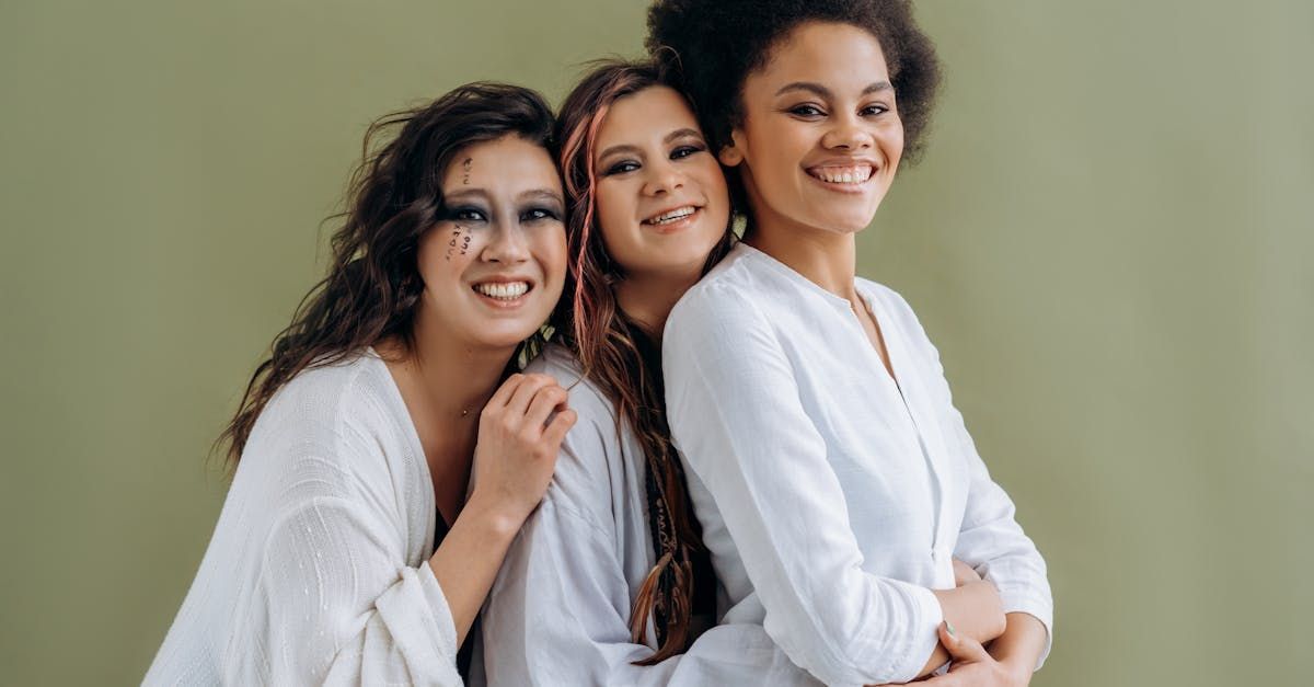 Three women are hugging each other and smiling for the camera.