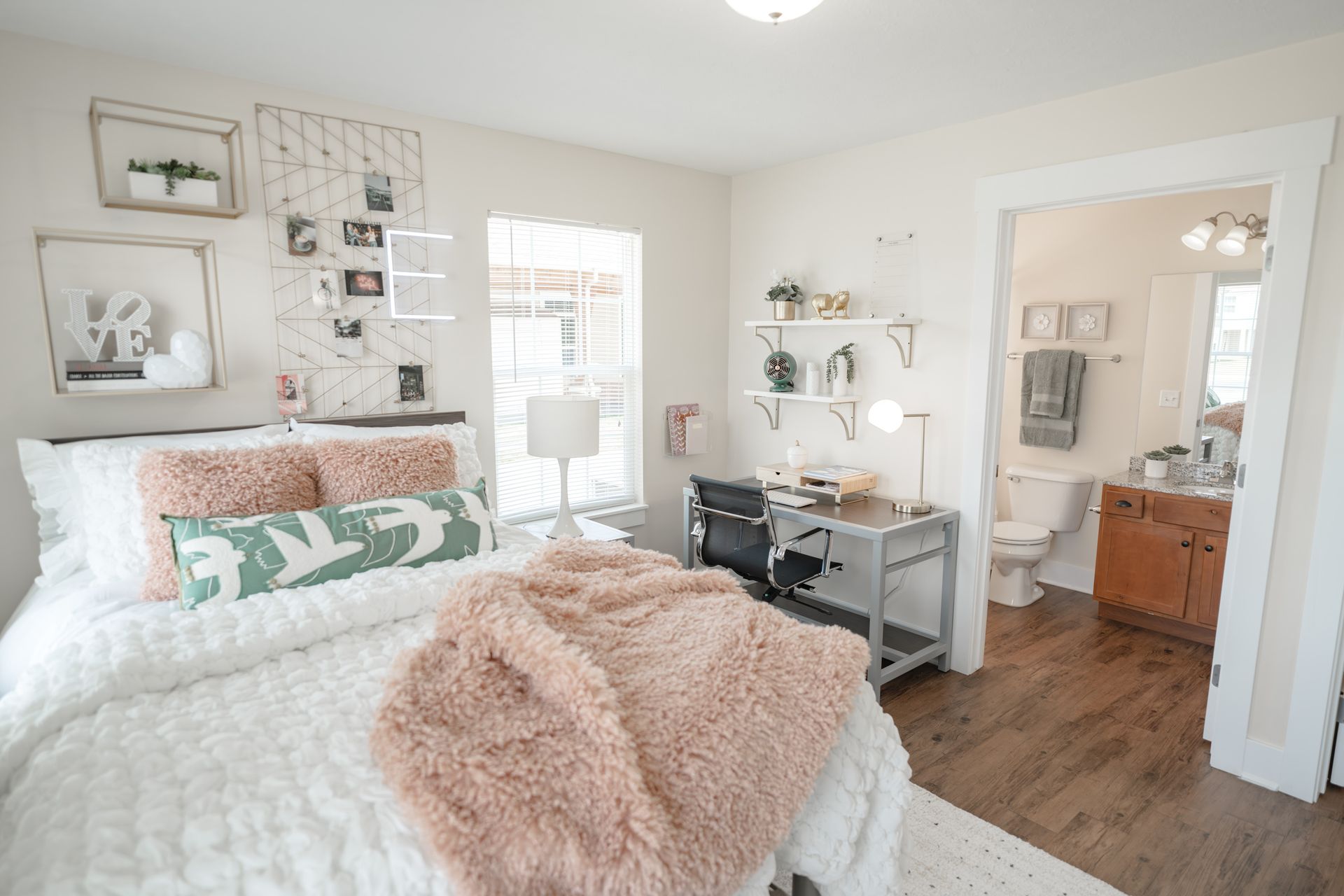 Living room with gray sofa, patterned chair, coffee table, TV, windows, and rug.