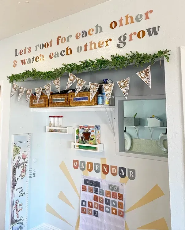 A wall with a quote that says let 's root for each other and watch each other grow