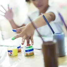 A child is painting with his hands on a table.