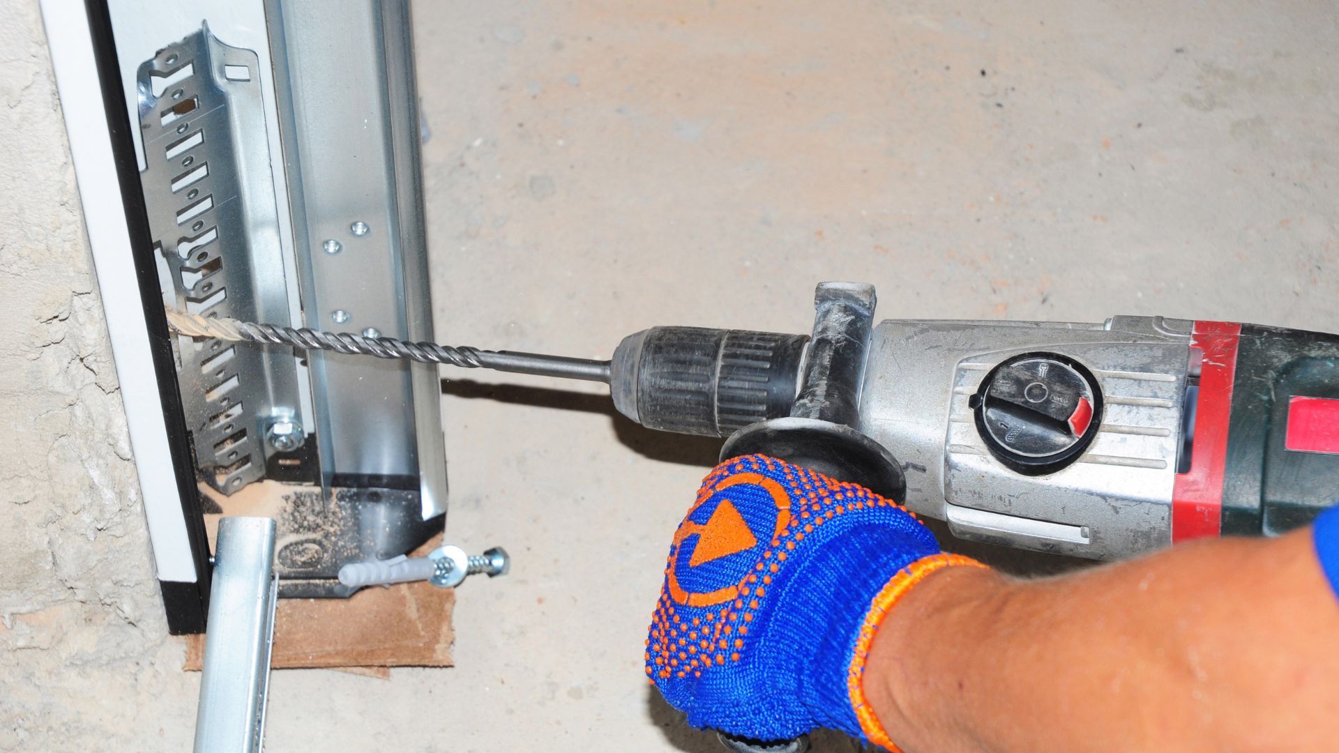 A person is using a drill to drill a hole in a wall.