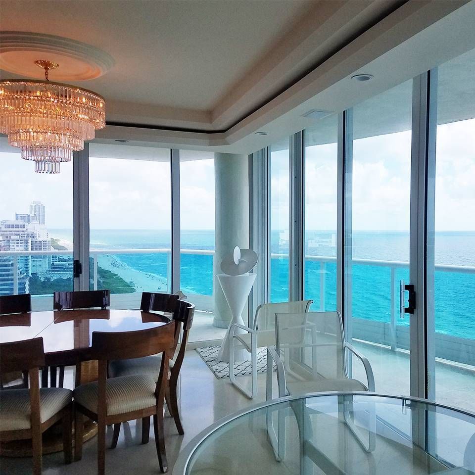 A dining room with a table and chairs and a view of the ocean