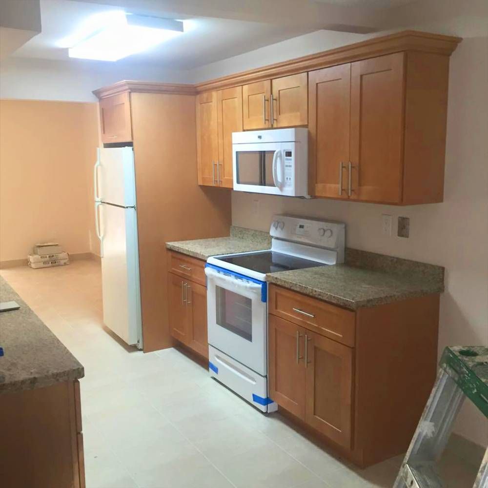 A kitchen with wooden cabinets a stove a microwave and a refrigerator